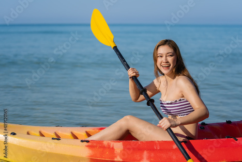 woman in swimsuit paddling a kayak boat in sea © geargodz