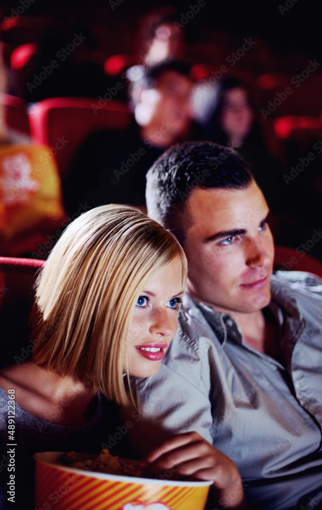 Here comes the scary part.... A cute young couple watching a scary movie in a cinema together. Here comes the scary part.... A cute young couple watching a scary movie in a cinema together.