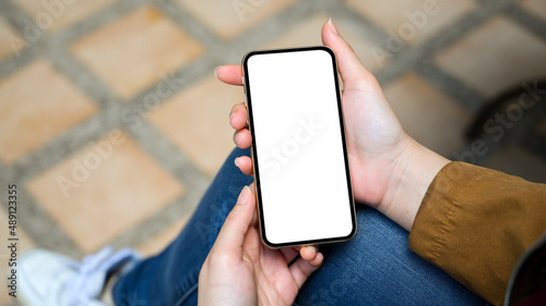 Female sitting in the park, relaxing on her mobile application.