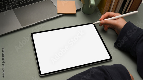 Close-up, Modern office table with female using stylus pen sketch on tablet. photo