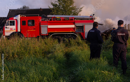 Fire service officers arrived at the scene. A fire truck at the scene of the fire. A fire in the village. Burning wooden houses in the village of Rantsevo, Tver region. photo