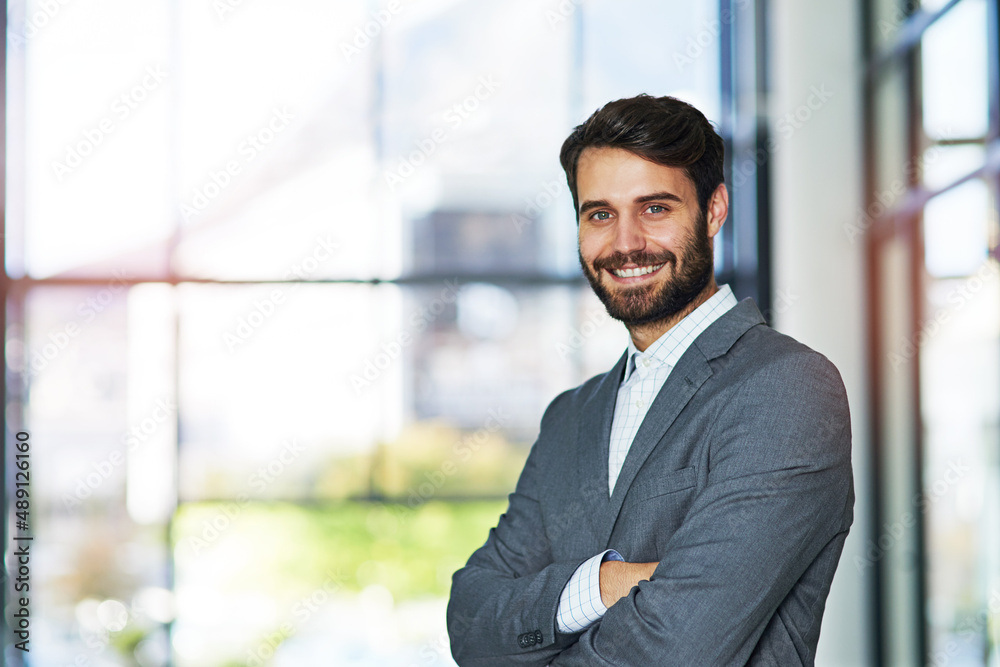 Self confidence is key to a successful career. Portrait of a confident young businessman standing in a modern office. Self confidence is key to a successful career. Portrait of a confident young businessman standing in a modern office.