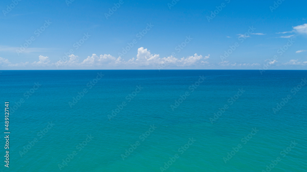 Aerial view of a blue sea surface water texture background and sky white clouds Aerial flying drone view Waves water surface texture on sunny tropical ocean in Phuket island Thailand