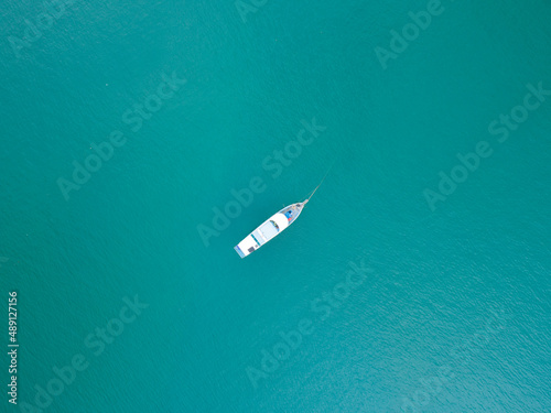 Aerial top view photo of traditional wooden fishing boat in tropical sea Phuket island Beautiful turquoise sea in summer day Copy space image for travel and tour