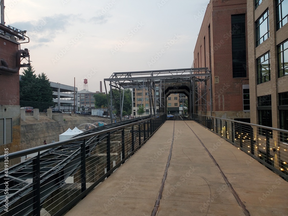 bridge in the city, downtown industrial setting, old train tracks, steel beams