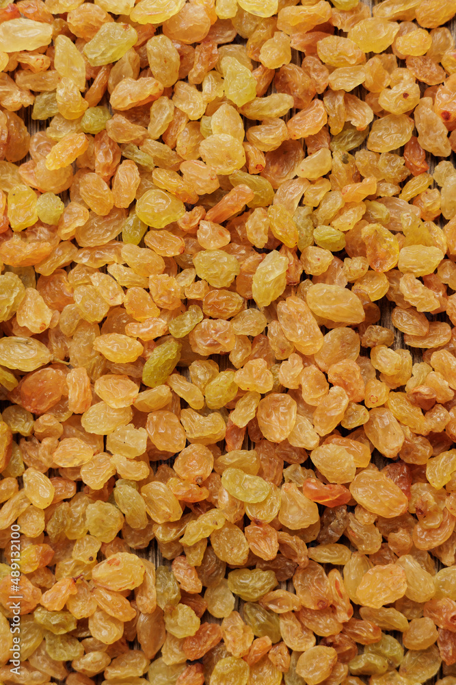 Organic golden raisins texture. Close up food background. Top view.