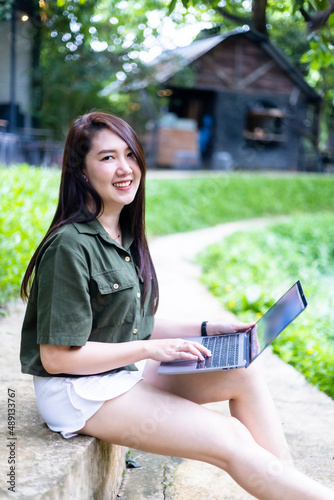 Happy of asian freelance people business female casual working with laptop computer outdoors at sunny summer day in park background,education and remote working communication concept