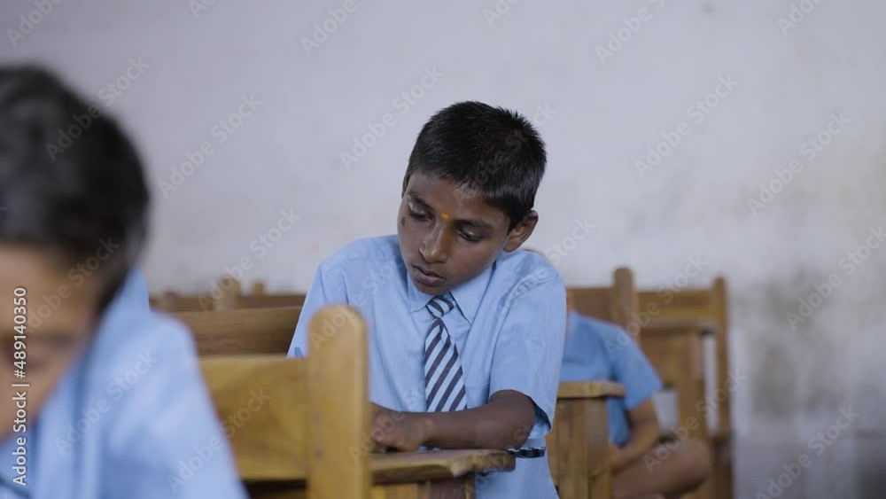 kid busy writing notes from blackboard at classroom - concept of Indian education, learning and public school kid busy writing notes from blackboard at classroom - concept of Indian education, learning and public school