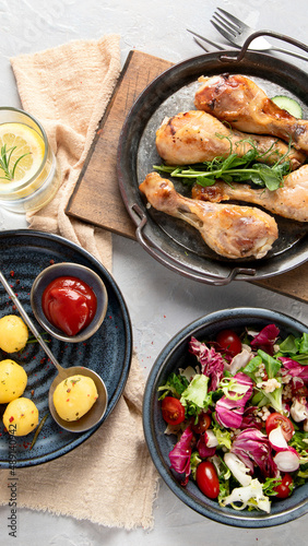 Baked chicken legs with salad and potatoes