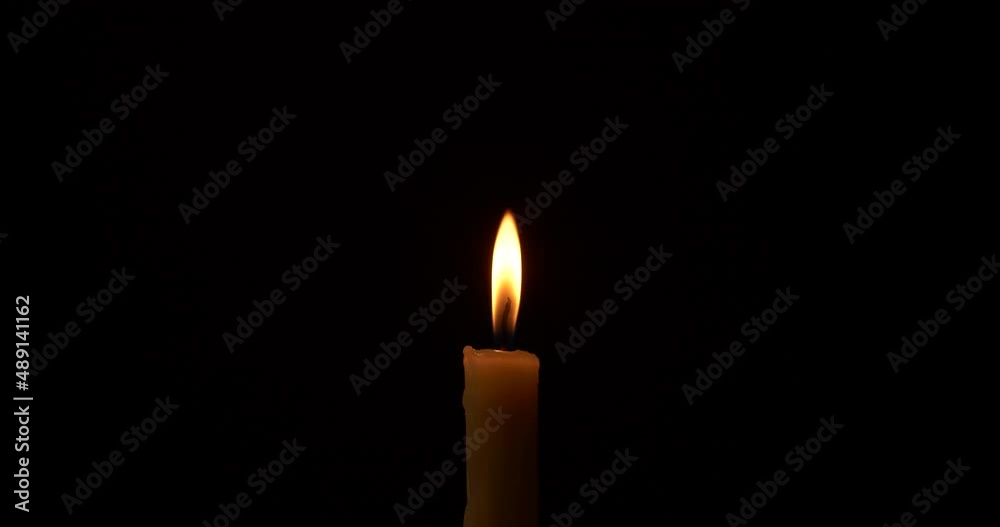 Closeup burning single candle flame isolated on black background Closeup burning single candle flame isolated on black background