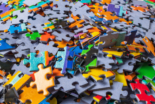 Close-up of scattered pieces of a jigsaw puzzle. Background image of colorful puzzle pieces.