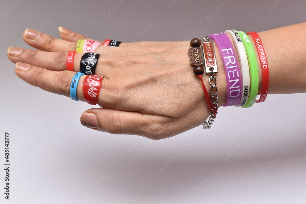 friendship bands and friendship rings in fingers and wrist.Hand full of