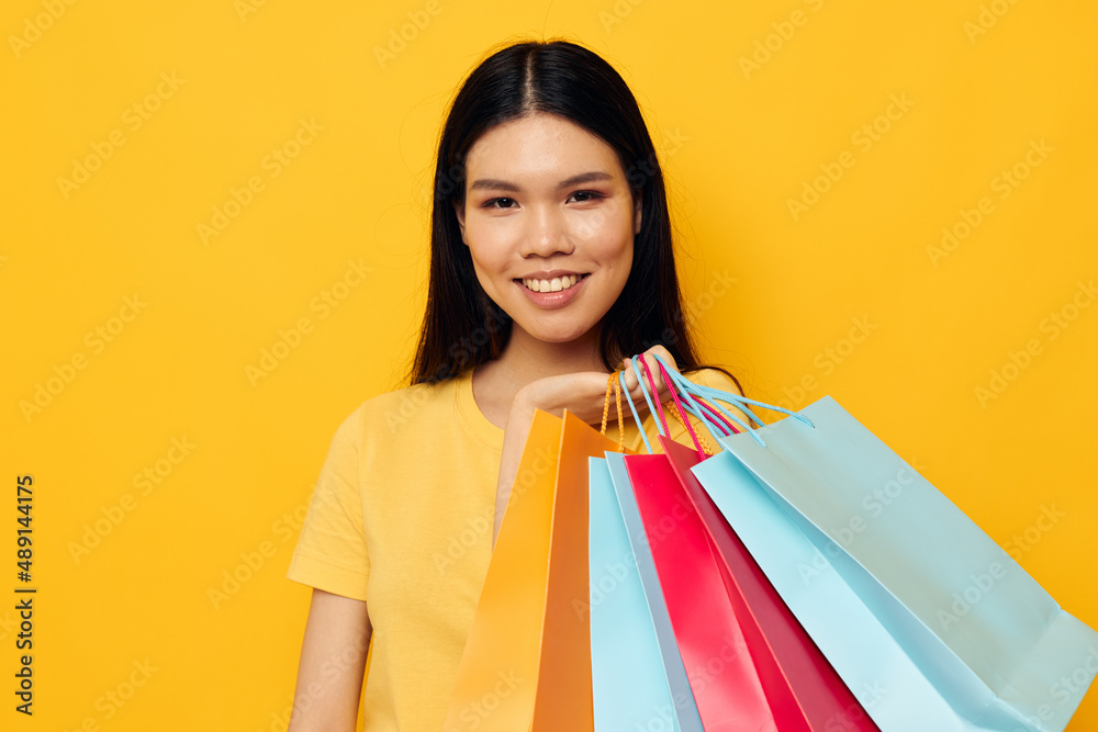 Portrait Asian beautiful young woman with packages in hands shopping isolated background unaltered Portrait Asian beautiful young woman with packages in hands shopping isolated background unaltered