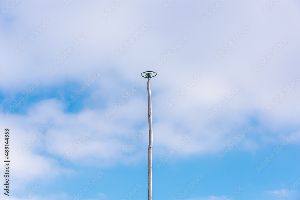 High pole for climbing athletes on the background of the sky.