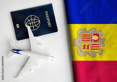 Flag of Andorra with passport and toy airplane. Flight travel concept.
