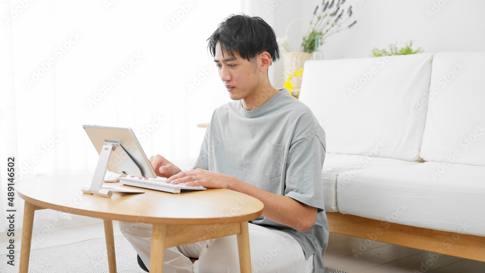 タブレットパソコンを使う若い男性 タブレットパソコンを使う若い男性