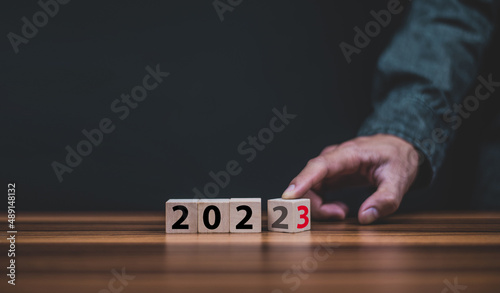 Hand hold wooden cubes 2023 and 2023 concept business change to new success