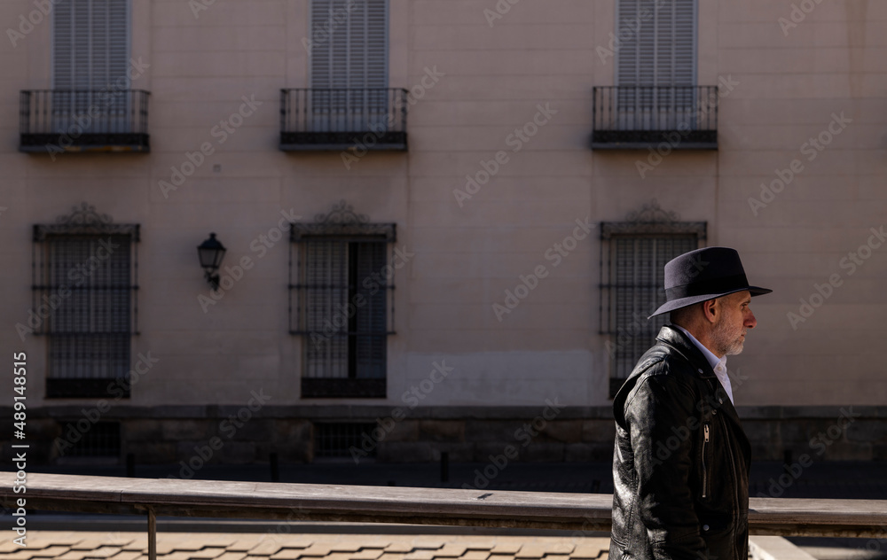 Portrait of adult man in hat and leather jacket on street. Madrid, Spain