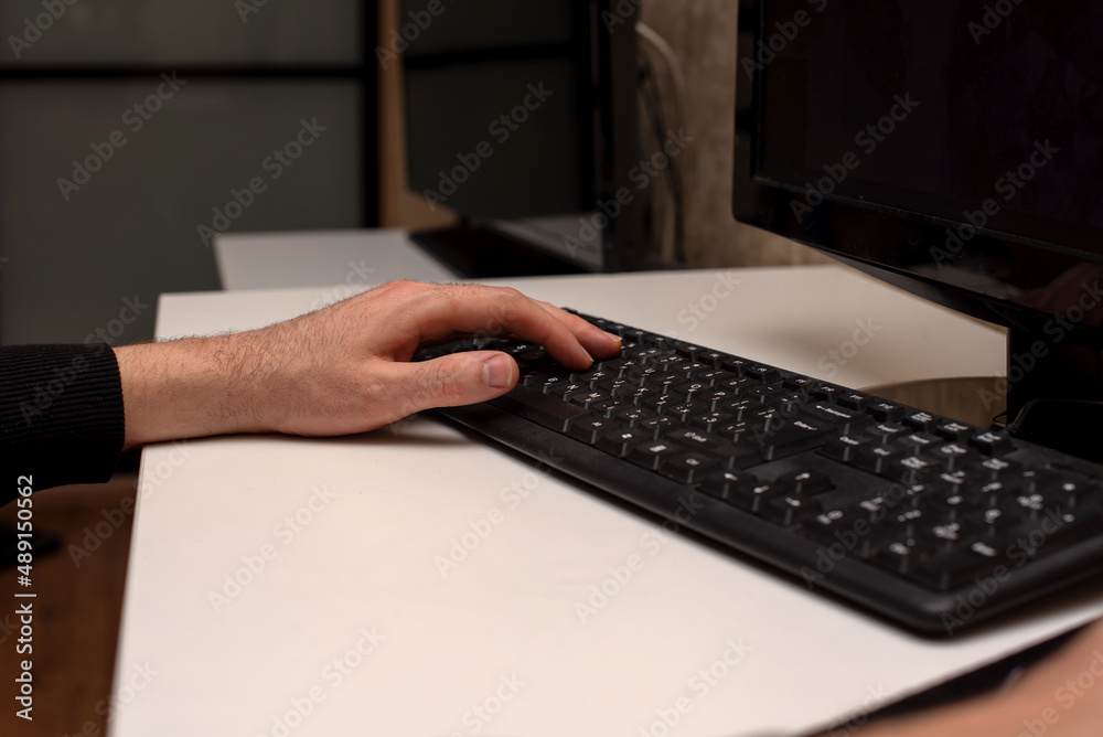 a man is working at a computer typing text on the keyboard a man is working at a computer typing text on the keyboard