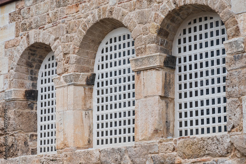 close-up white wrought iron bars in an arch-shaped window in an old house