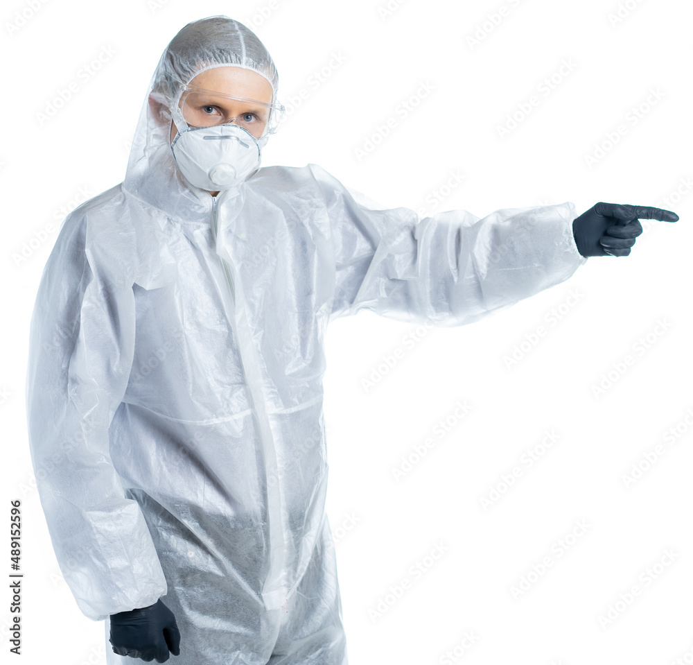 A man in a protective suit points a finger to the side. place for an inscription. pandemics, epidemics, virus, coronavirus, flu, SARS. chemical hazard, infection. precautions. isolated A man in a protective suit points a finger to the side. place for an inscription. pandemics, epidemics, virus, coronavirus, flu, SARS. chemical hazard, infection. precautions. isolated
