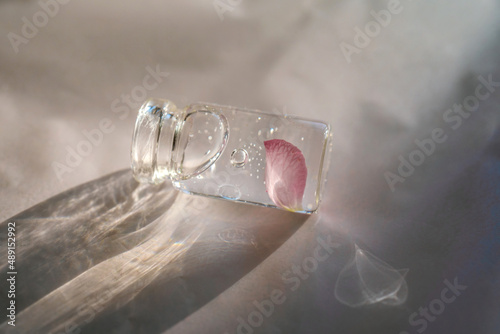 A bottle of cosmetic gel on a pink background.