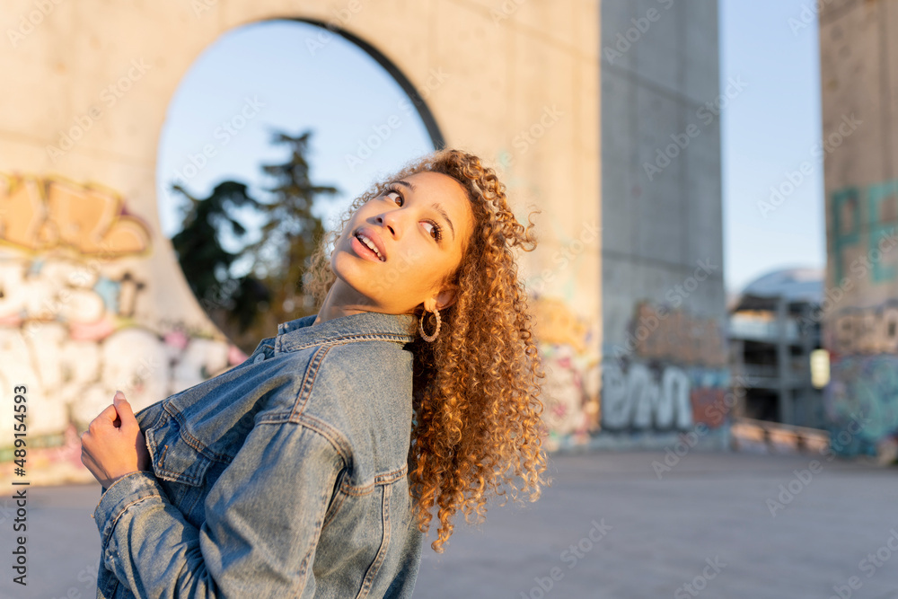 Fototapeta premium pretty woman curly blonde hair, at sunset in urban place