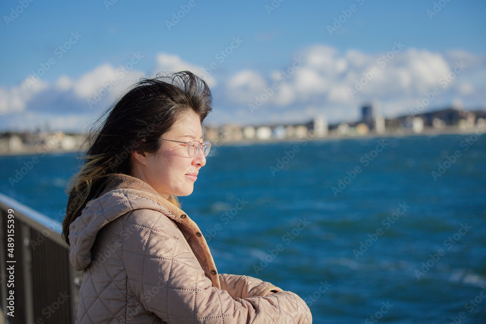 冬の海岸で散歩している若い女性の姿