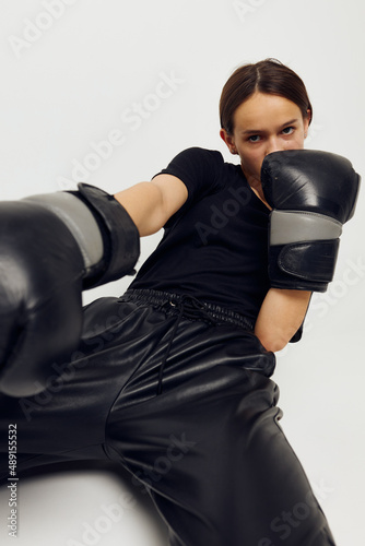 photo pretty girl in boxing gloves on the floor in black t-shirt light background