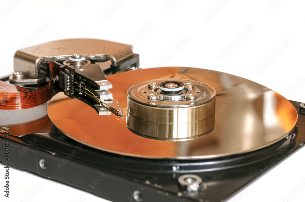 Disassembled hard disk drive close-up isolated on white background. Hard disc drive inside details. Disassembled hard disk drive close-up isolated on white background. Hard disc drive inside details.