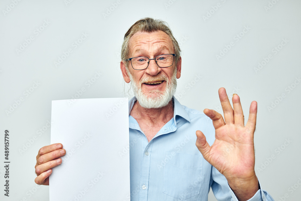 Portrait elderly man holding a sheet of paper copy-space posing cropped view
