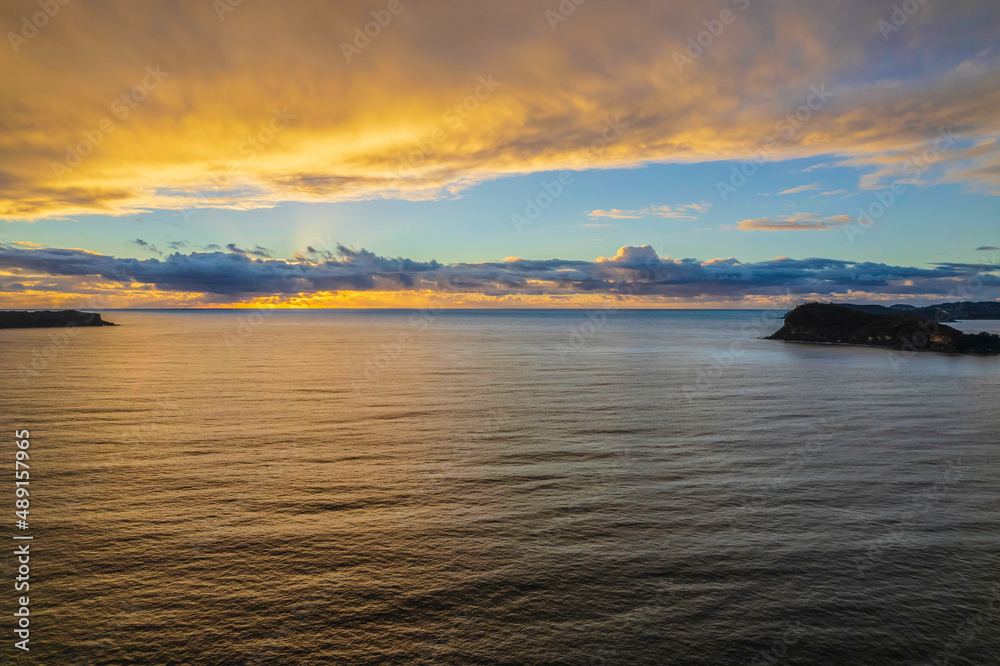 Aerial sunrise seascape with overcast sky and rain clouds