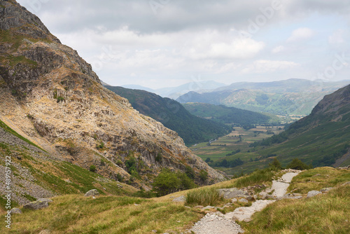 Distant mountain views of Blencathra, Bleaberry Fell, Grange Fell and Seatoller from a rocky trail below Base Brown in the English Lake District, UK. photo