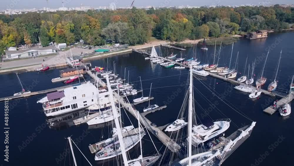 Large and small boats stand on the pier on a summer day within the city - drone Large and small boats stand on the pier on a summer day within the city - drone