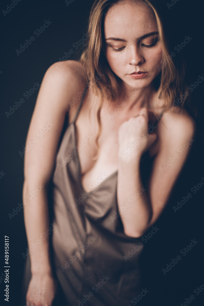 Young girl with a European Slavic appearance and brown hair, in a beige chemise, a dress with straps, playfully looks at the camera, acting skills and simple facial expressions on her face Young girl with a European Slavic appearance and brown hair, in a beige chemise, a dress with straps, playfully looks at the camera, acting skills and simple facial expressions on her face