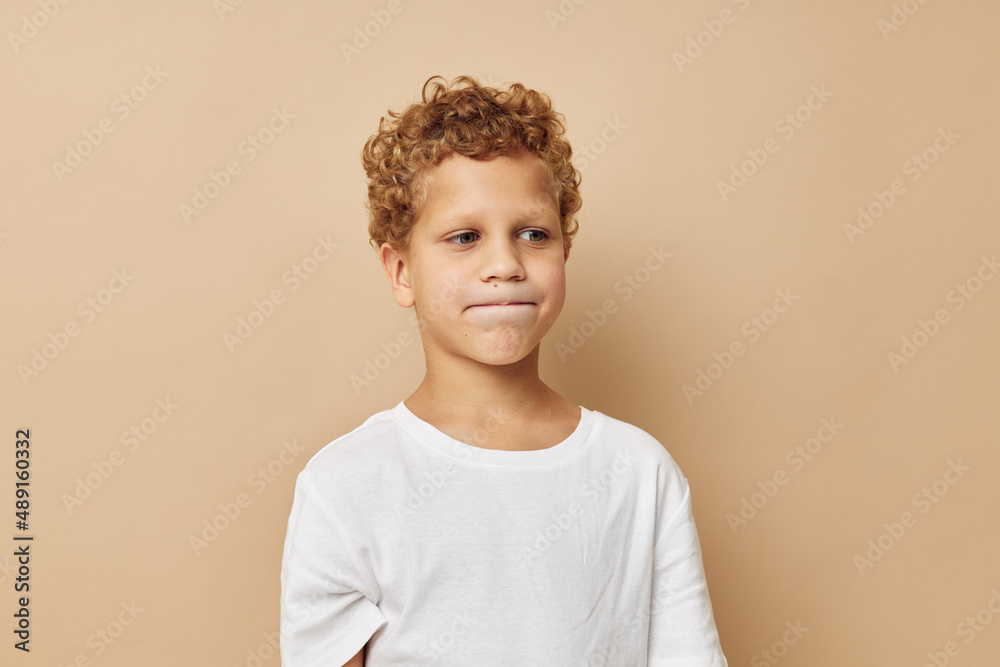 boy with curly hair in a white t-shirt posing boy with curly hair in a white t-shirt posing
