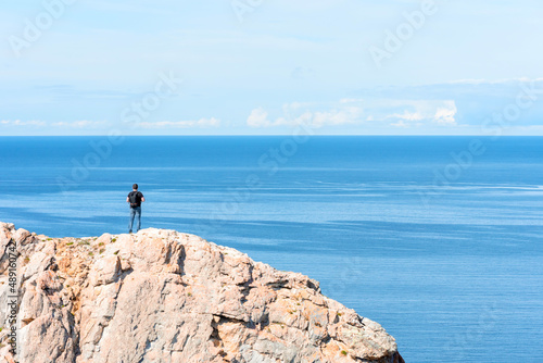 Man standing on a rock at the end of earth. Hiking or travel concept. Explore the great outdoors. Beauty of nature