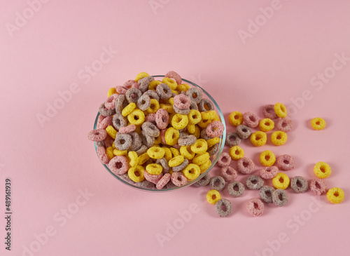 cereal breakfast rings on a pink background in a plate and scattered nearby