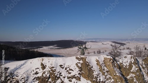 bronze sculpture in the form of a tree on a steep cliff of Olkhon Island on Baikal Island