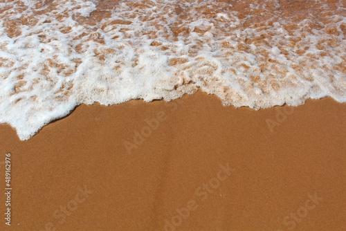 Texture of ocean water retreating over red sand typical of PEI, Canada