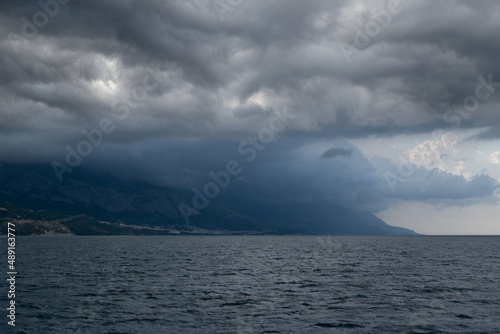 Mountain Biokovo disappears in dark clouds on the Croatian coast from the Adriatic Sea