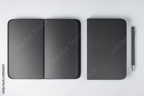 Top view on all-black notebooks with black empty pages and plain pen on white surface background. 3D rendering, mock up