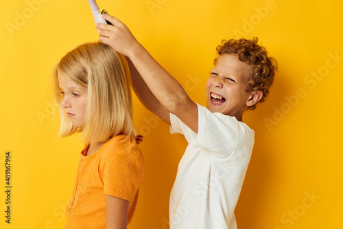 a boy combing a girl's blonde hair