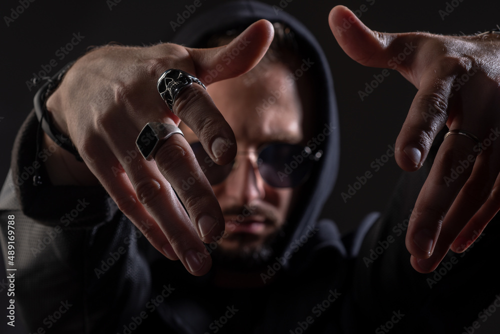 Brutal man, handsome serious male model. Close up portrait of guy with serious face. Hand rap gestures.