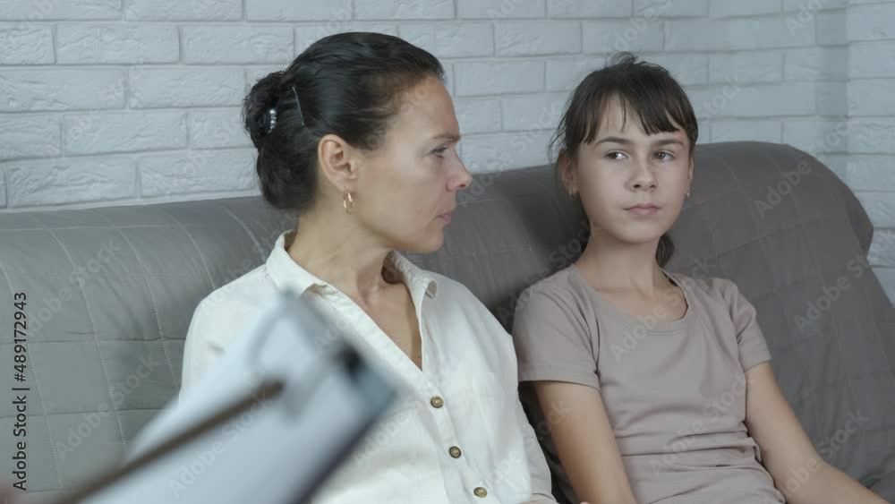 Mobile messaging in cabinet. A girl start to chatting by her mother in psychological office. Mobile messaging in cabinet. A girl start to chatting by her mother in psychological office.