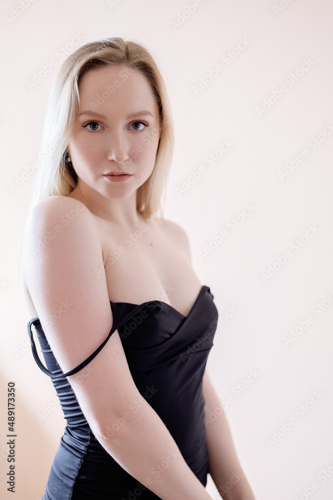 Graceful young woman posing against beige wall. Graceful young woman posing against beige wall.