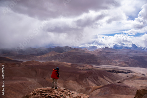 A geologist taking a view of the Copiapó volcano during a summer storm  at 5000 meters above sea level, Andes of Atacama region photo