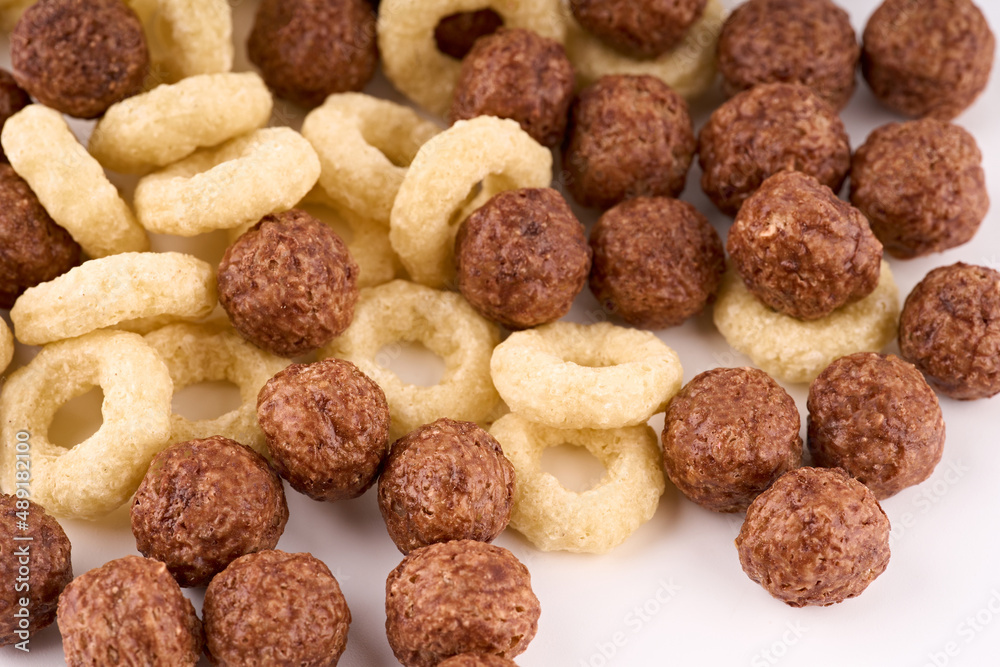 Variety of cold cereals, quick breakfast for kids overhead shot. Quick breakfast. Chocolate balls isolated on a white background. Rings isolated on a white background. Variety of cold cereals, quick breakfast for kids overhead shot. Quick breakfast. Chocolate balls isolated on a white background. Rings isolated on a white background.