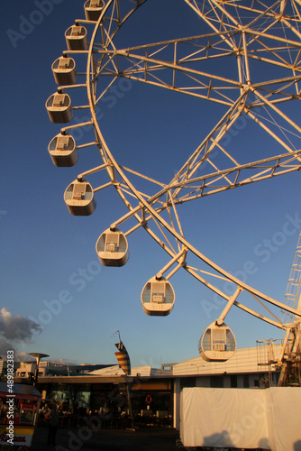 Yellow ferris wheel against blue sky in Manila Bay, Manila, Philippines
