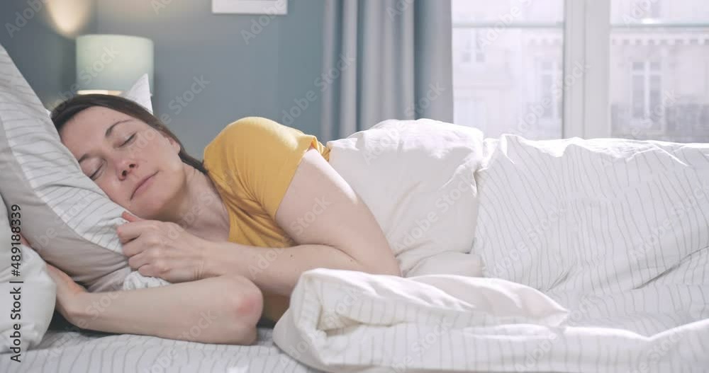 Portrait of calm young woman sleeping well in comfortable cozy bed on soft pillow. Caucasian female resting, enjoying healthy good sleep nap in the morning. Portrait of calm young woman sleeping well in comfortable cozy bed on soft pillow. Caucasian female resting, enjoying healthy good sleep nap in the morning.